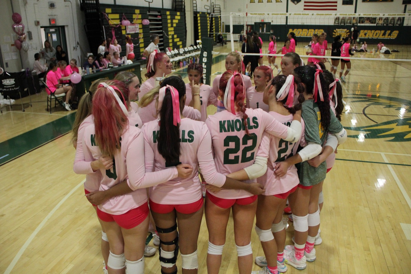 Morris Knolls team huddle at the Dig Pink game